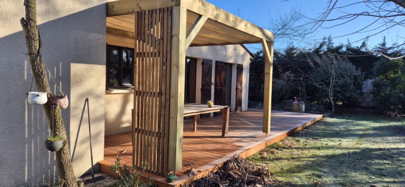 Pergola bois adossée à la maison en pin autoclave classe 4 avec stores rétractables sur câbles, réalisation sur mesure à Saint-Médard-en-Jalles.