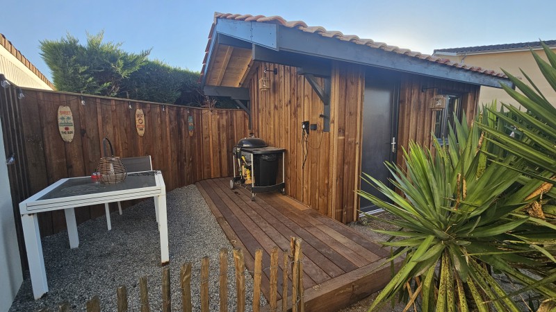 Abri de jardin sur mesure à Saint-Jean-d’Illac avec avancée fonctionnelle pour cuisine d’été, bardage bois et toiture double pente en tuiles.