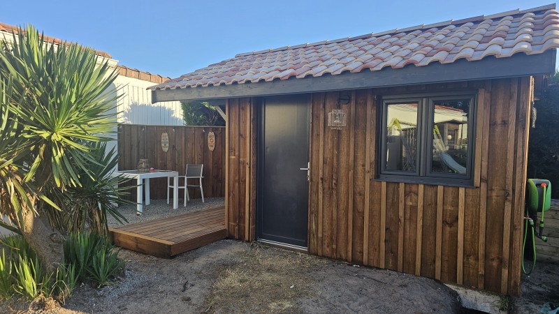 Abri de jardin sur mesure de 12 m² à Saint-Jean-d’Illac, bois en volige avec couvre-joint et toiture tuiles double pente.